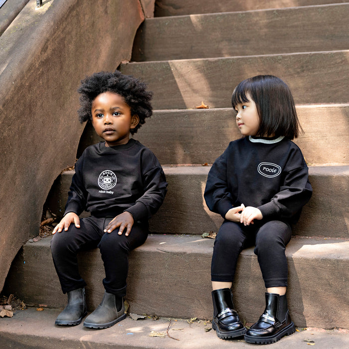 Toddler boy wearing a Rooie and Friends black Robot Baby sweatshirt set