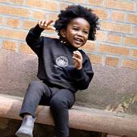Toddler boy wearing a Rooie and Friends black Robot Baby sweatshirt set