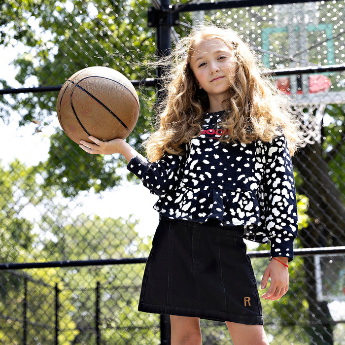 Girl wearing Rooie and Friends Dalmatian ruffle sweatshirt at a basketball court